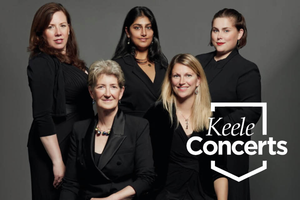 5 women stand together looking at the camera, a grey background