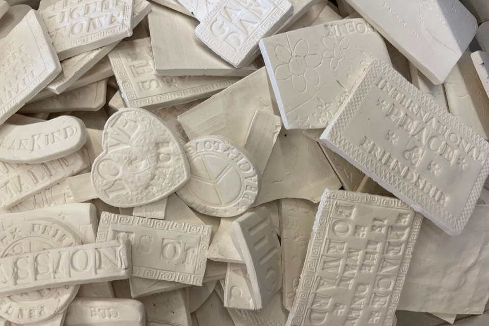 clay tiles stacked up close printed with peaceful phrases