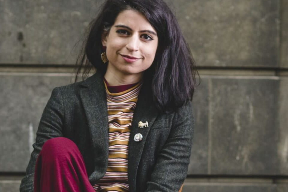 Colour photographic portrait of Noreen Masud looking directly at camera