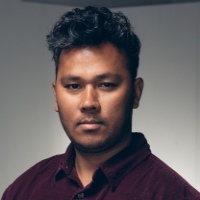 Man looking forward, dark hair, deep red shirt