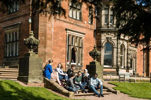 Students sat on some steps in the sun outside Keele Hall